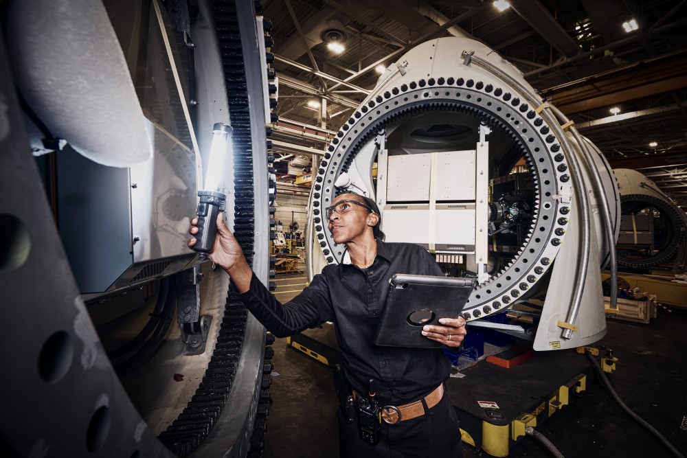 Person working in a factory holding a flashlight